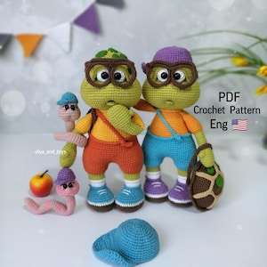 Puede incluir: Patrón de crochet para dos tortugas verdes que llevan gafas y llevan una mochila y una bolsa. Las tortugas llevan pantalones cortos naranja y azules. El patrón está en inglés.