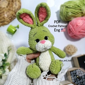 May include: Green crocheted bunny rabbit plush toy with pink ears and white accents. PDF Crochet Pattern Eng.