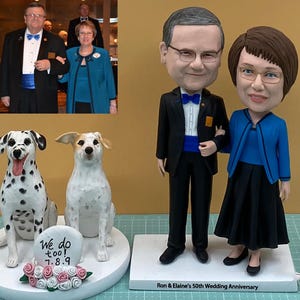 Może przedstawiać: Spersonalizowany zestaw figurek z głową kiwającą przedstawiający parę w formalnym stroju, z miniaturowym zdjęciem pary w tle. W zestawie znajdują się również dwie figurki psów i znak z napisem "We do too! 7.8.9". Na podstawie widnieje napis "Ron & Elaine's 50th Wedding Anniversary."