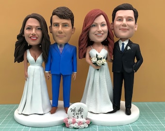 May include: Four custom bobblehead figurines of a wedding party. Two couples are dressed in wedding attire. The bride on the left wears a white dress, and the groom wears a blue suit. The other bride wears a white dress and holds a bouquet.