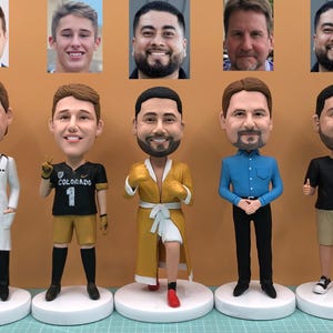 Puede incluir: Una colección de cinco figuras de bobblehead personalizadas, cada una representando a un hombre diferente. Los bobbleheads están vestidos con varios atuendos, incluyendo una bata de médico, un uniforme deportivo, una bata, una camisa abotonada y una camiseta. Cada figura tiene una cara detallada.