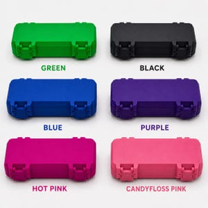 May include: A collection of six small, rectangular cases in various colors: green, black, blue, purple, hot pink, and candyfloss pink. Each case has two secure latches and the color name printed below.