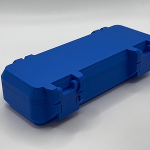 K&ouml;nnte beinhalten: Eine leuchtend blaue, rechteckige Box mit strukturierter Oberfl&auml;che. Die Box hat einen Klappdeckel und zwei sichere Verschl&uuml;sse an der Vorderseite. Sie dient zum Schutz und zur Aufbewahrung.
