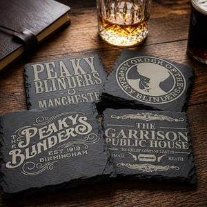 Puede incluir: Cuatro posavasos cuadrados de pizarra gris oscuro con diseños grabados y texto. Los posavasos presentan las palabras "Peaky Blinders" y otros textos relacionados.