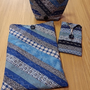 May include: Three blue and white patterned fabric pouches with zipper closures. The pouches are made of different fabrics with various geometric patterns. The largest pouch is a flat rectangle, the medium pouch is a rounded rectangle, and the smallest pouch is a narrow rectangle.