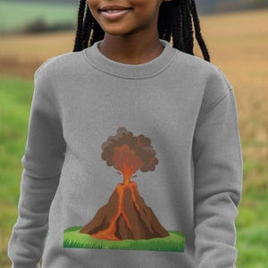 May include: A gray sweatshirt with a cartoon illustration of a volcano erupting with orange lava and a brown and gray smoke plume.
