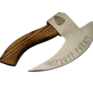 K&ouml;nnte beinhalten: Eine geschwungene Handaxt mit einer polierten, silberfarbenen Metallklinge, die mit eingravierten Runenzeichen und einem Tannenzapfen-Symbol versehen ist. Der Griff besteht aus hellbraunem Holz mit sichtbarer dunkler Maserung und geschwungener Form.