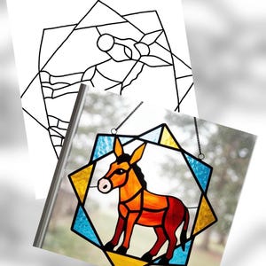 May include: Stained glass donkey in a geometric frame. The donkey is depicted in shades of orange and red, with a pink nose and black hooves. The frame features blue and yellow geometric shapes, with a chain for hanging.