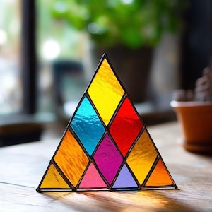 Peut inclure: Une pyramide en verre coloré avec un motif de diamants jaunes, bleus, rouges, oranges, roses et violets.
