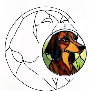 May include: A stained glass window featuring a dachshund dog with brown, orange, and black colouring. The dog is wearing a white collar and is set against a green background.