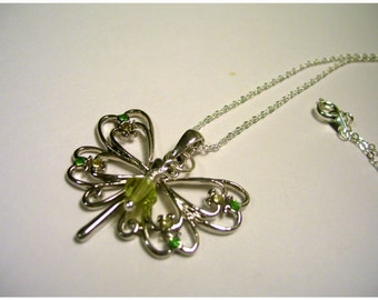 May include: A silver necklace with a dragonfly pendant. The dragonfly has green and yellow accents.