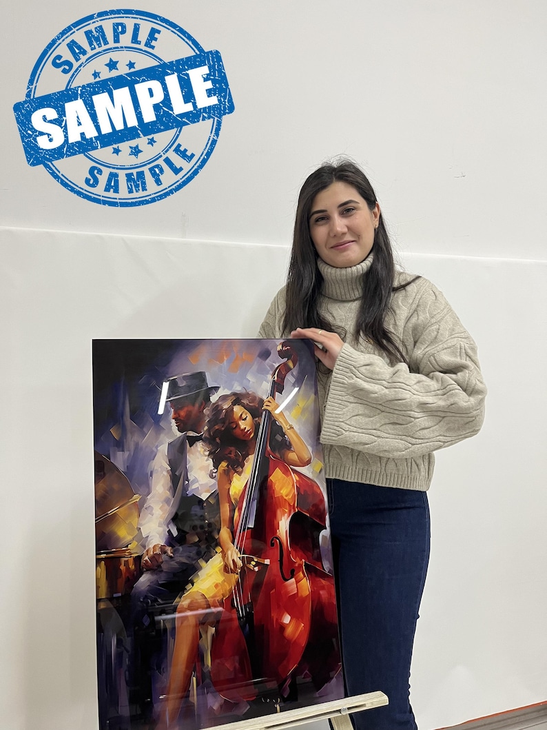 May include: A framed art print featuring a jazz-themed illustration. The artwork depicts a man in a hat and a woman playing a double bass. The print has a glossy finish and is held by a person. The print has a blue stamp that says "SAMPLE".
