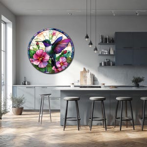 May include: Round wall art featuring a stained-glass style hummingbird with vibrant purple, green, and blue plumage. The bird is surrounded by pink hibiscus flowers and green leaves. The artwork is displayed in a modern kitchen setting.