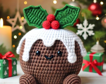 May include: A round brown crochet plush toy shaped like a Christmas pudding with white icing, three red berries, and two green leaves on top. The plush features two black bead eyes and a small stitched smile on its front surface.