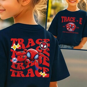 May include: Navy blue t-shirt featuring a red and blue cartoon spider design with the text "TRACE-E" and "Spider and his amazing friends". The shirt has a retro style design with a cartoon spider and star accents.