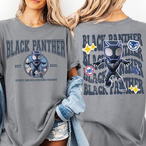 May include: Gray t-shirt featuring a Black Panther design. The front of the shirt has the words "Black Panther" above a cartoon image of the character. The back of the shirt repeats "Black Panther" with additional graphics.