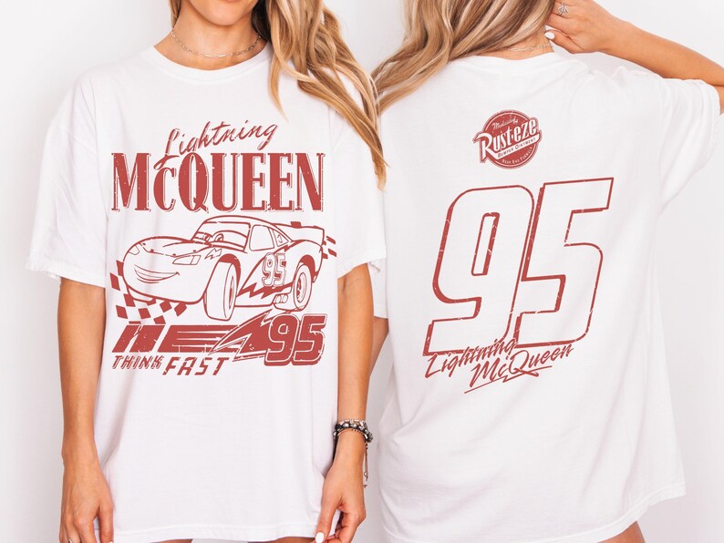 May include: White t-shirt with a red graphic of Lightning McQueen from the Cars film. The front design includes the text "Lightning McQueen," a race car illustration, and "95." The back displays "95" and "Lightning McQueen."