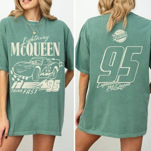 May include: Green Lightning McQueen t-shirt with a distressed white graphic on the front and back. The front features the text "Lightning McQueen", a car illustration, and "95". The back displays "95" and "Lightning McQueen".