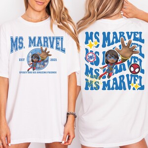 May include: White t-shirt featuring the text "MS. MARVEL" in blue, with a graphic of Ms. Marvel and the text "SPIDEY AND HIS AMAZING FRIENDS". The back of the shirt repeats the text "MS MARVEL" with additional graphics.