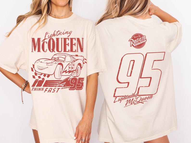 May include: A cream-coloured t-shirt with a red graphic of Lightning McQueen race car and the text "Lightning McQueen" and "95". The back of the shirt has a large "95" and "Lightning McQueen" in red.