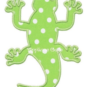 May include: Green lizard applique with white polka dots. The lizard is in a standing position with its tail curled around its body.