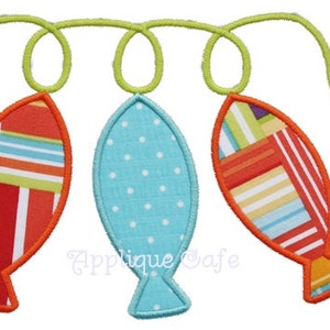 May include: Three colorful, decorative fish-shaped ornaments with orange borders are connected by a green, swirled string. The fish have patterned fabric in red, blue, and white. One fish is light blue with white polka dots.