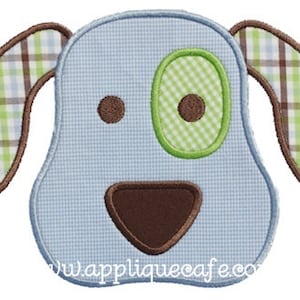 May include: Blue and brown applique of a dog with green and white plaid ears. The dog has a brown nose and a green eye.