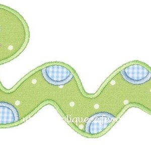 May include: A green felt applique of a smiling worm with white polka dots and blue and white gingham circles.