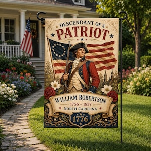 May include: A garden flag featuring a patriotic design. The flag displays an illustration of a man in colonial attire holding a rifle, with the American flag in the background. Text includes "Descendant of a Patriot" and "William Robertson 1756-1837 North Carolina 1776".