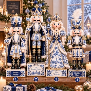 May include: Four decorative nutcracker figures in blue and white, featuring intricate snowflake and forest patterns, gold accents, and crowns. Each stands on a rectangular base labelled with text including Winter Wishes, The Bennett Family, Blue Christmas, and Holiday Cheer.