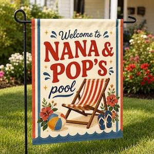 以下が含まれることがあります： Welcome to NANA & POP'S poolという赤と青の文字が書かれた長方形のガーデンフラッグ。赤と白のストライプのラウンジチェア、カラフルなビーチボール、赤いハイビスカスの花、青いビーチサンダルが描かれています。