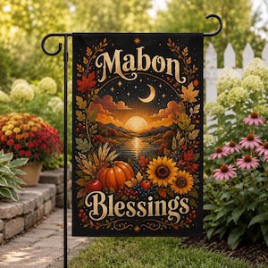 以下が含まれることがあります： 黒い背景に金色の「Mabon Blessings」という文字が記された長方形のガーデンフラッグ。中央のイラストには、湖に沈む夕日、秋の葉、カボチャ、ヒマワリ、赤いリンゴ、ベリーが描かれています。