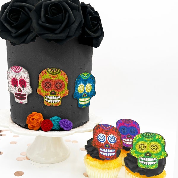 May include: A black cake decorated with colorful sugar skull toppers. The cake is topped with black roses and sits on a white cake stand. Four cupcakes are decorated with colorful sugar skull toppers.