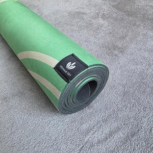 May include: A rolled up green and white yoga mat with a black label that says "Neuh&auml;us Zen".