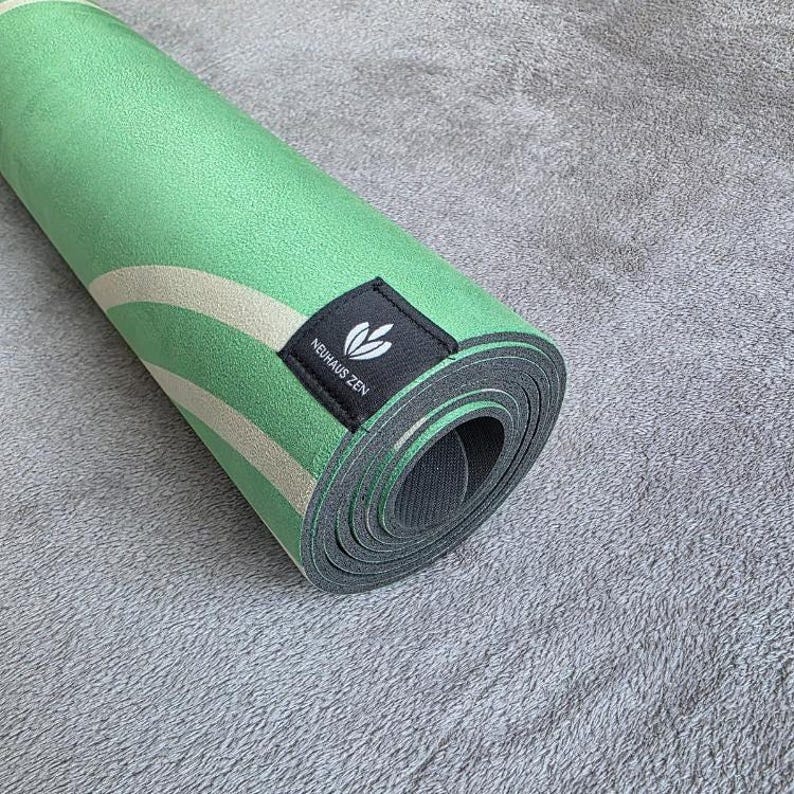 May include: A rolled up green and white yoga mat with a black label that says "Neuh&auml;us Zen".
