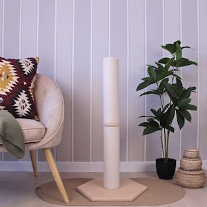 May include: A white ceramic mug with a black handle and the text "But First, Coffee" in a bold, black font. The mug is set against a blurred background, suggesting a cosy setting.