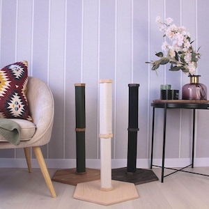 May include: Three cat scratching posts with different coloured coverings. The posts are made of wood and have a natural finish. The posts are on a white background.