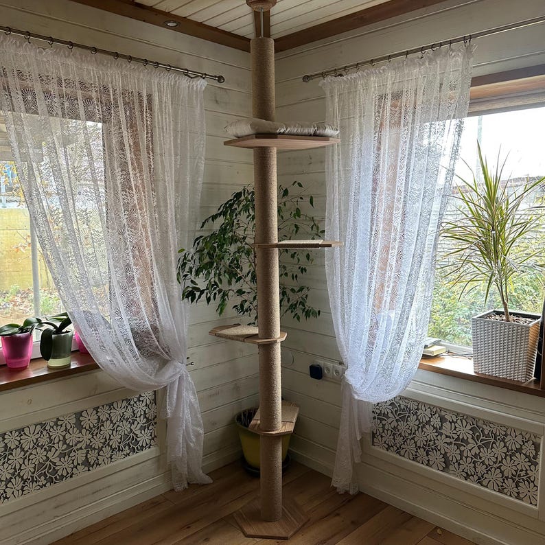 Brown floor-to-ceiling cat tree tower with jute-wrapped shelves, a cozy top perch with removable cushion, and natural wood construction. Perfect for large cats and small spaces, combining style and functionality