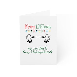 Puede incluir: Tarjeta de felicitación blanca con el texto "Merry LIFTmas" en rojo y verde, con una ilustración de una barra con pesas. La tarjeta también incluye la frase "may your lifts be heavy & holidays be light."