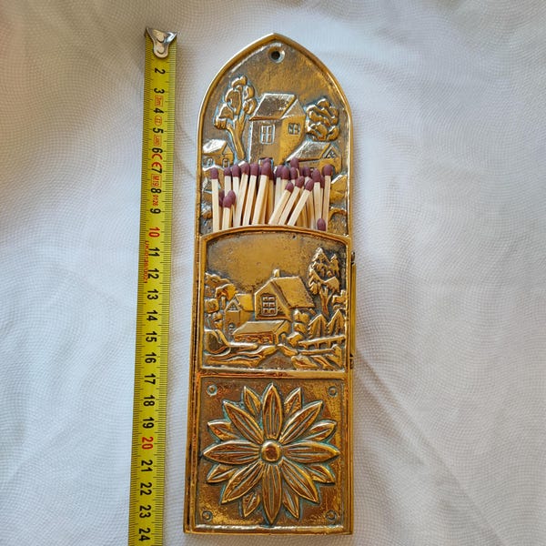 Vintage brass match holder. Scenic and floral decoration. Striking surface on the side. Wall decor