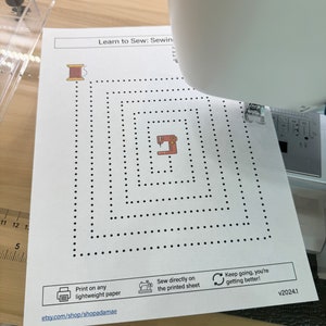May include: A printable sewing maze with a sewing machine and spool of thread. The maze is designed to be sewn directly on the printed sheet. The text on the page reads "Learn to Sew: Sewing Maze", "Print on any lightweight paper", "Sew directly on the printed sheet", "Keep going, you're getting better!" and "etsy.com/shop/shopadamae".