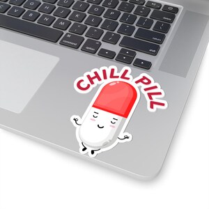 May include: A white pill with a red cap, with a smiling face and arms outstretched, as if in a yoga pose. The pill is on a laptop with the text "CHILL PILL" in red letters.