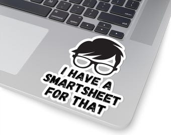 Op de afbeelding: Een zwart-witte sticker met een cartoonfiguur met een bril en de tekst "Ik heb een Smartsheet daarvoor."