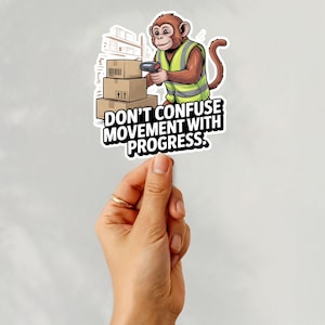 May include: A sticker showing a cartoon monkey in a safety vest using a barcode scanner on boxes. The sticker reads "DON'T CONFUSE MOVEMENT WITH PROGRESS."
