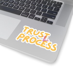 Może przedstawiać: Żółta naklejka z tekstem "TRUST the PROCESS" w pogrubionym, zaokrąglonym kroju pisma. Słowo "the" jest różowe.