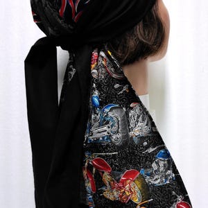 May include: Black biker skull cap with a flame design in red, yellow, and blue. The cap features a motorcycle print on a black background. The cap has long black ties.