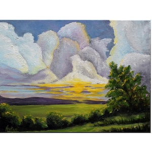 May include: An oil painting of a landscape featuring a vibrant sunset. The sky is filled with large, fluffy white clouds tinged with yellow and purple hues. A green field and trees are in the foreground, with a hint of a mountain range in the distance.