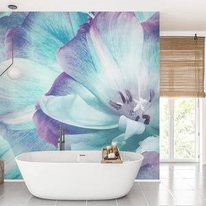 May include: A modern bathroom featuring a large, white, oval bathtub. The wall behind the tub showcases a vibrant floral mural in shades of blue, purple, and white. The room includes wooden accents, a window, and a minimalist design.