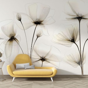 May include: A yellow sofa with a white cushion sits in front of a white wall with a floral design. The flowers are white and translucent, with black outlines.