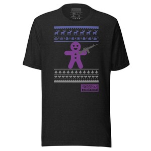 Può includere: Una maglietta nera con un omino di pan di zenzero viola che tiene una pistola e un motivo a maglia di maglione natalizio grigio. Il testo "IMPERIAL" e "UNDERWEAR" è stampato sulla maglietta.
